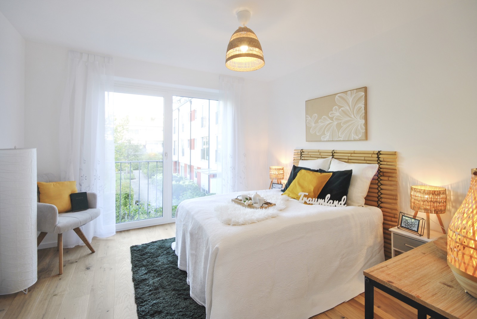 Schlafzimmer mit Doppelbett, Eichenparkett und bodentiefem Fenster